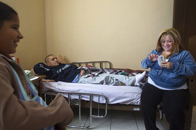 Francisco Diaz rests in an elderly care home where he recuperating from injuries in Mexicali, Mexico Sunday, Jan. 26, 2014. With Diaz are his niece Priscilla and sister Jacqueline. Diaz was born in Mexico but grew up in Las Vegas with a green card. Diaz was beaten and robbed after he was deported to Mexicali.