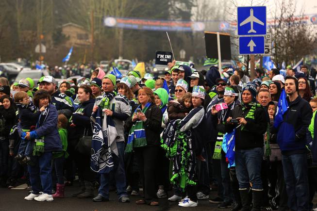 Thousands of football fans wait to catch a glimpse of the Seattle Seahawks on South 188th Street in SeaTac, Wash. Sunday, Jan. 26, 2014. The Seahawks drove past the crowd on route to the airport for Super Bowl XLVIII. 