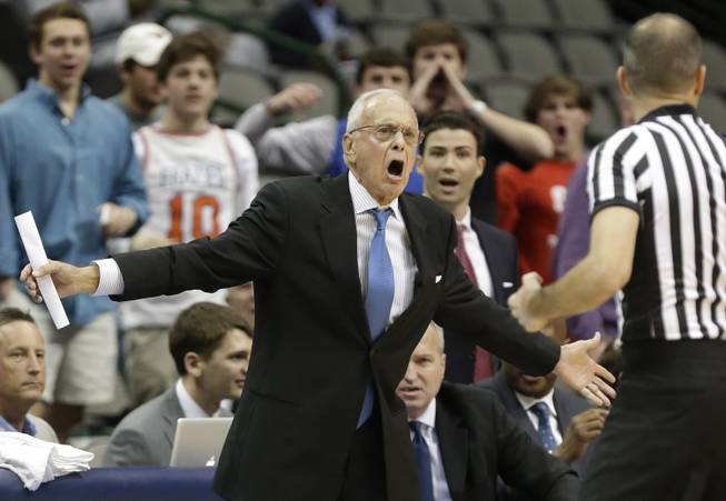 SMU head coach Larry Brown, left, yells at a referee during the first half of an NCAA college basketball game against TCU in Dallas, Friday, Nov. 8, 2013.