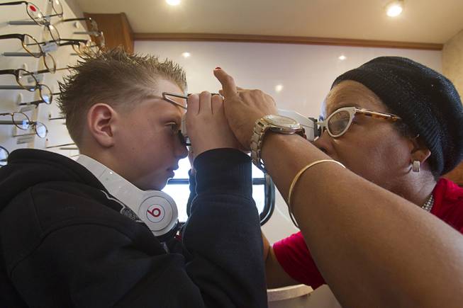 Volunteer Tina Berr, right, takes some measurements on Kevin Stewart, 10, a fifth grader at Deskin Elementary School, in the OneSight mobile vision center at the Andre Agassi College Preparatory Academy Tuesday, Jan. 27, 2014. Over 100 Clark County School District students received free eye exams and new glasses. OneSight is an organization providing access to eye care and eyewear to underserved communities.