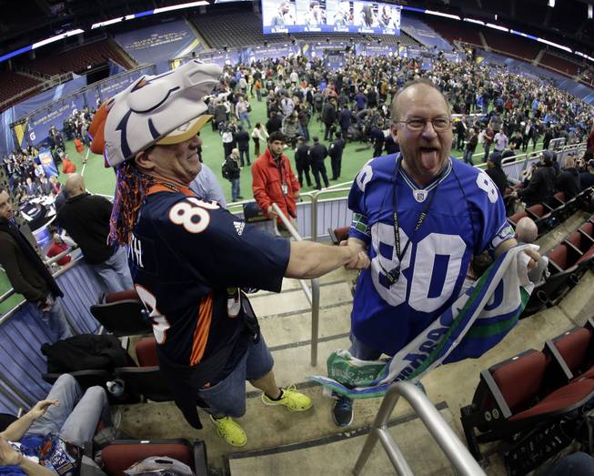 Seattle Seahawks fan Paul Dierolf, right, and Denver Broncos fan Lonnie Moreno have some fun during media day for the NFL Super Bowl XLVIII football game Tuesday, Jan. 28, 2014, in Newark, N.J. 