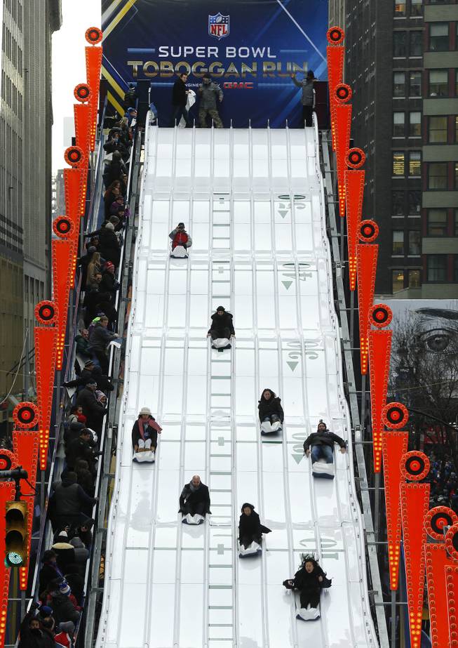 People ride the Super Bowl Toboggan Run along on Super Bowl Boulevard in New York on Friday, Jan. 31, 2014. The Seattle Seahawks play the Denver Broncos on Sunday at the stadium in the NFL Super Bowl XLVIII football game.