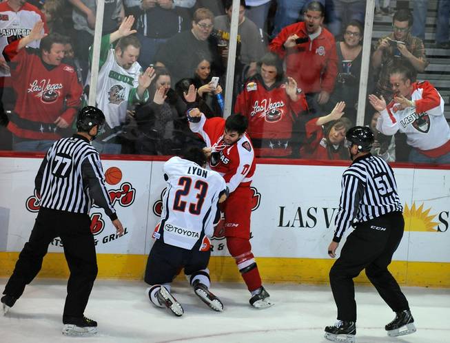 Las Vegas fans cheer on Wranglers forward Adam Huxley (17) as he fights Ontario Reign forward Brett Lyon (23) during an ECHL game on Friday night at the Orleans Arena.