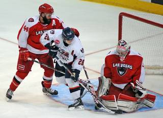 Las Vegas Wranglers goaltender Travis Fullerton makes a save against Ontario Reign forward Mario Lamoureux during the third period of a game on Saturday evening at the Orleans Arena. Wranglers defenseman Nolan Julseth-White is also pictured on the play.
