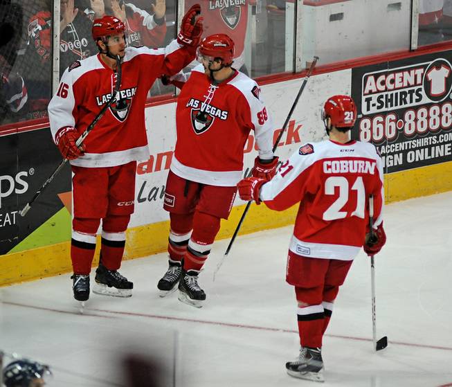 Wranglers forward Matt Tassone (16) is congratulated by teammates after scoring a late third period goal against the Ontario Reign on Saturday night.