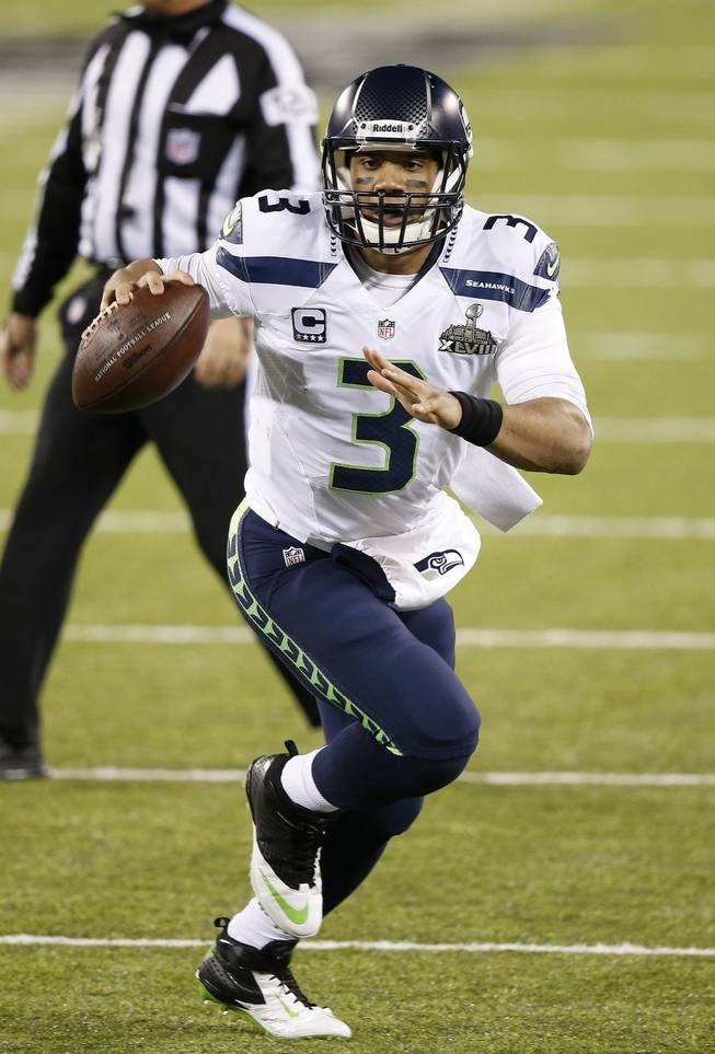 Seattle Seahawks' Russell Wilson rolls out during the first half of the NFL Super Bowl XLVIII football game against the Denver Broncos Sunday, Feb. 2, 2014, in East Rutherford, N.J.