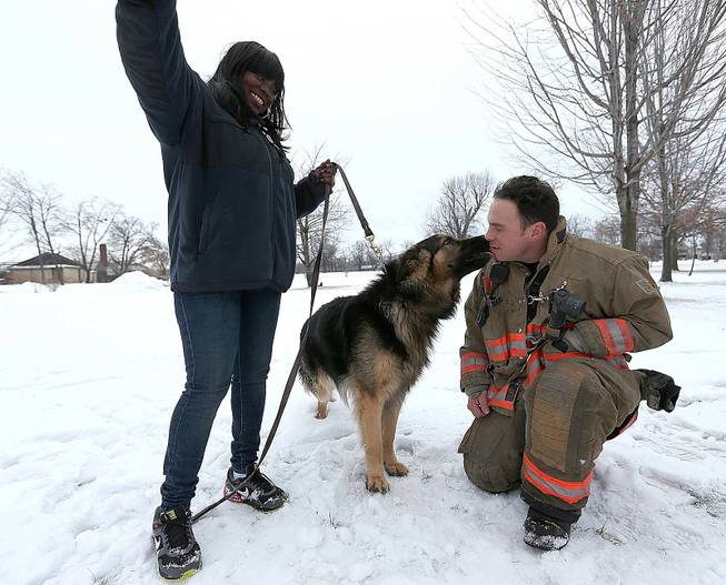 Rescue 1 firefighter Michael Paveljack gets a kiss from Mack the dog he rescued from a sinkhole in Buffalo, N.Y., on Sunday, Feb. 2, 2014. 