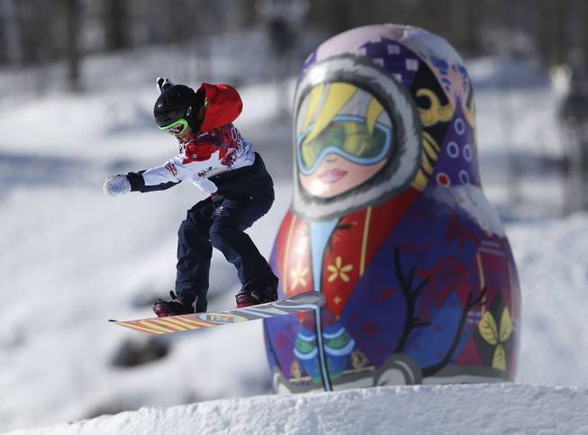 A competitor takes a jump past a giant matryoshka doll during a Snowboard Slopestyle training session at the Rosa Khutor Extreme Park, prior to the 2014 Winter Olympics, Tuesday, Feb. 4, 2014, in Krasnaya Polyana, Russia. 