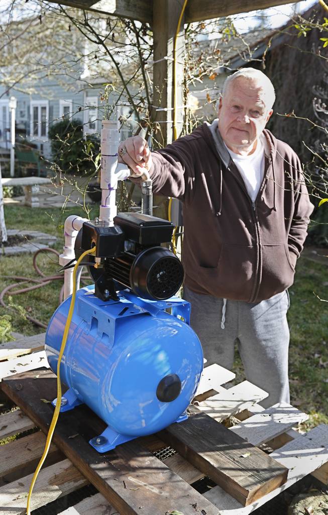 In this photo taken Tuesday, Feb. 4, 2014, Charles Davison, a retired high school principal, installed a pump on a unused well on to help supplement his household water supply at his home in Willits, Calif.  In the midst of an historic drought and area reservoirs holding less than a 100-day supply of water, Willits city leaders have banned lawn watering, car washing and have asked restaurants to serve water only upon request.