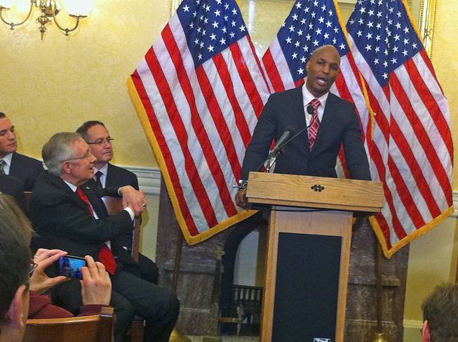 Senate Majority Leader Harry Reid looks on as IFC light heavyweight champion Bernard Hopkins speaks about the Professional Fighters Study in the Capitol, Tuesday, Feb. 4, 2014.