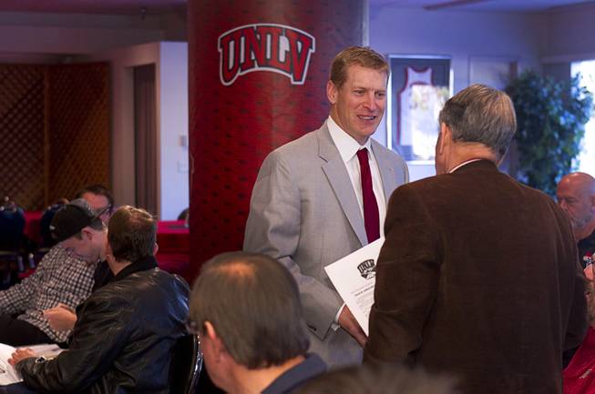 UNLV head football coach Bobby Hauck talks with former regent Mark Alden before a news conference on new recruits at UNLV Wednesday, Feb. 5, 2014.