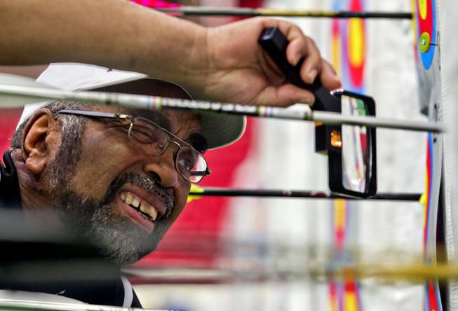 Tournament official Ron West of Capitol Heights, Maryland, uses a magnifying glass to score an arrow during the Adult Freestyle Championship in the South Point Arena as part of the Vegas Round of the 2014 NFAA World Archery Festival on Friday, Feb. 7, 2014.
