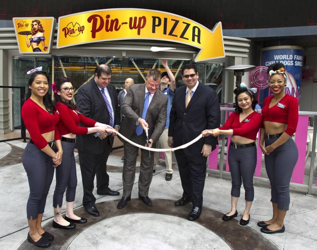 Planet Hollywood President David Hoenemeyer cuts the dough and is joined by Vice President of Food and Beverage Jeffrey Frederick, Director of Food and Beverage Terrence O'Donnell and Pin-Up Pizza girls at the grand opening Friday, Feb. 7, 2014, at Planet Hollywood.