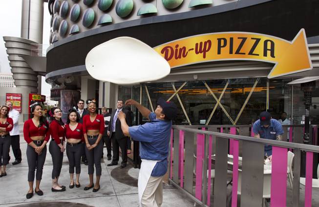 Pizza tosser Jorge Torres impresses the Pin-Up Pizza girls and others with his dough tossing skills on Pizza Day while celebrating their grand opening Friday, Feb. 7, 2014.