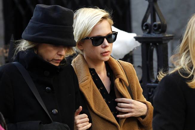 Actress Michelle Williams, right, arrives at the Church of St. Ignatius Loyola for the private funeral of actor Philip Seymour Hoffman Friday, Feb. 7, 2014, in New York. Hoffman, 46, was found dead Sunday of an apparent heroin overdose.