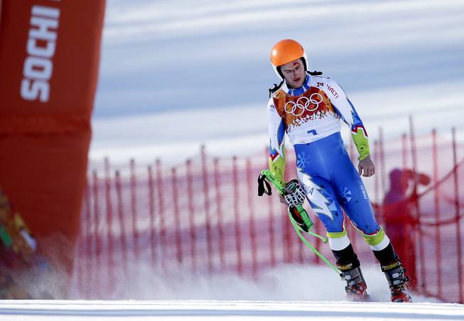 Slovenia's Rok Perko arrives in the finish area after crashing during a men's downhill training run for the Sochi 2014 Winter Olympics, Saturday, Feb. 8, 2014, in Krasnaya Polyana, Russia. 