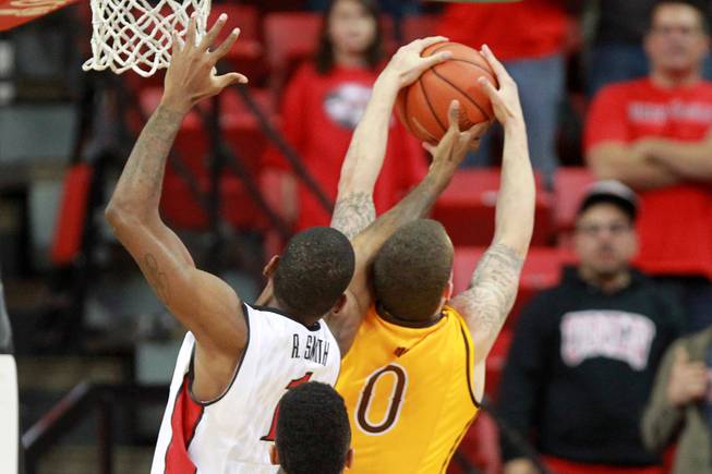 UNLV forward Rosco Smith knocks a rebound away from  Wyoming guard Josh Smith during the final seconds of their game Saturday, Feb. 8, 2014 at the Thomas & Mack Center. UNLV won 48-46.