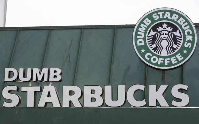 The sign at Dumb Starbucks coffee in Los Angeles is displayed Monday, Feb. 10, 2014. The store resembles a Starbucks with a green awning and mermaid logo, but with the word "Dumb" attached above the Starbucks sign. Starbucks spokeswoman Laurel Harper says the store is not affiliated with Starbucks and, despite the humor, the store cannot use the Starbucks name.