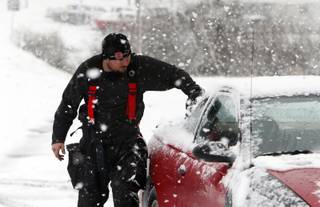 Firefighter Robbie Hairell scrapes snow off of his car Tuesday Feb. 11,  2014 in Dog Town, Ala.  A winter storm dropped from 1 inch to 3 inches of wintry precipitation across a wide area, turning trees and roads white and forcing hundreds of schools, businesses and government offices to close or open late.  (AP Photo/Hal Yeager)