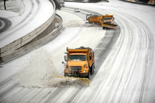Snow plows clear downtown lanes on Interstate 75/85 during a winter storm on Wednesday, Feb. 12, 2014, in Atlanta.  Across the South, winter-weary residents woke up Wednesday to a region encased in ice, snow and freezing rain, with forecasters warning that the worst of the potentially 