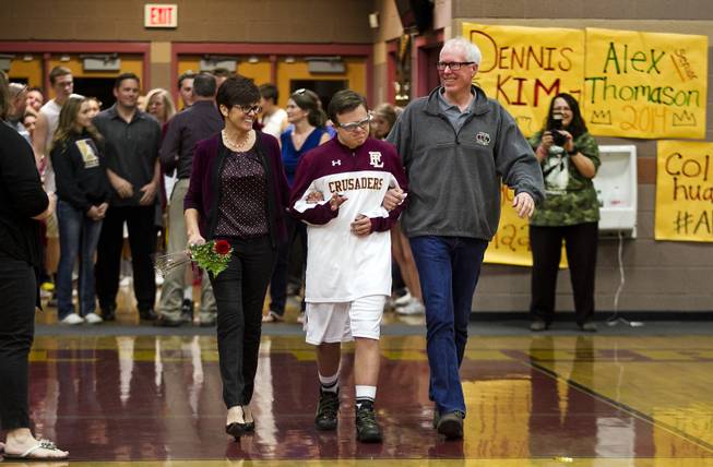 Shelley, Clayton and John Rhodes walk onto the court as they participate in "senior night" recognitions before the start of the varsity basketball game against Pahrump on Thursday, Feb. 13, 2014.