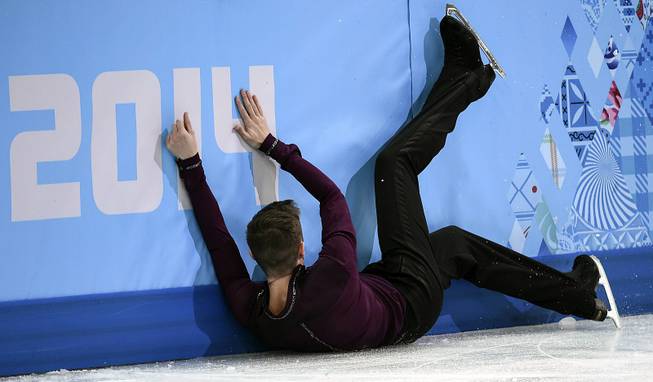 Jeremy Abbott of the United States crashes into the boards after falling during the men's short program figure skating competition at the Iceberg Skating Palace during the 2014 Winter Olympics, Thursday, Feb. 13, 2014, in Sochi, Russia. 