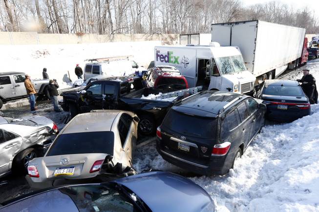 Vehicles are piled up in an accident, Friday, Feb. 14, 2014, in Bensalem, Pa. Traffic accidents involving multiple tractor trailers and dozens of cars have completely blocked one side of the Pennsylvania Turnpike outside Philadelphia and caused some injuries. 