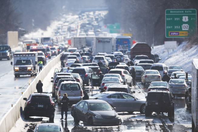 Vehicles are piled up in an accident Friday, Feb. 14, 2014, in Bensalem, Pa. Traffic accidents involving multiple tractor trailers and dozens of cars completely blocked one side of the Pennsylvania Turnpike outside Philadelphia and caused some injuries.