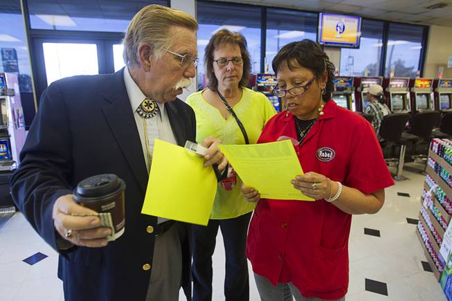 Volunteers Edward Cotton, left, and Maria Brezinski, center, talk with Rebel store manager Patty Patacsil as they hand out fliers on missing woman Jessie Foster near Jones Boulevard and Tropicana Avenue Monday, Feb. 17, 2014. Foster, a Canadian, went missing from North Las Vegas in 2006.