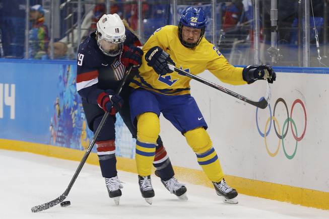 Gigi Marvin of the United States and Emma Eliasson of Sweden battle fro control of the puck during the second period of the 2014 Winter Olympics women's semifinal ice hockey game at Shayba Arena Monday, Feb. 17, 2014, in Sochi, Russia.