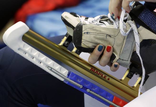 Tatiana Borodulina of Russia laces up before the start of the short track speedskating competition at the Iceberg Skating Palace during the 2014 Winter Olympics, Tuesday, Feb. 18, 2014, in Sochi, Russia. 