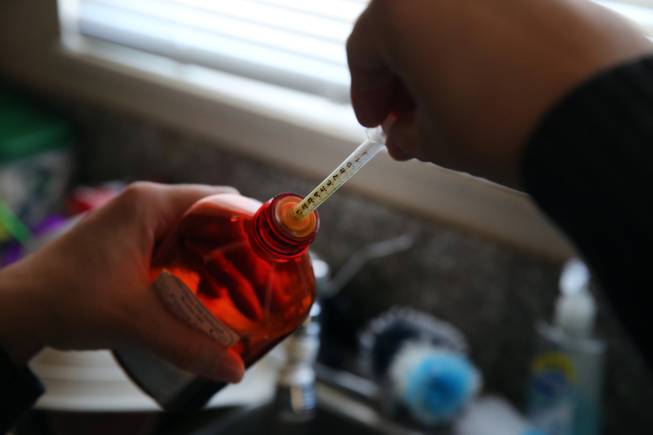 In this Feb. 7, 2014 photo, Aileen Burger loads an oral syringe with cannabis-infused oil used as medicine for her 4-year-old daughter Elizabeth, who suffers from severe epilepsy and is receiving the experimental treatment with a special strain of medical marijuana, at her home in Colorado Springs, Colo.
