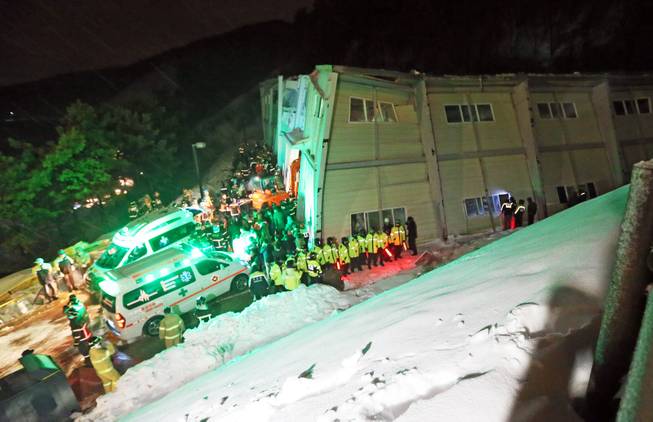 Rescue workers search for survivors from a collapsed resort building in Gyeongju, South Korea, Monday, Feb. 17, 2014. South Korean police and news reports say that dozens of university students are feared trapped after a buildingis roof collapsed because of recent heavy snowfall.