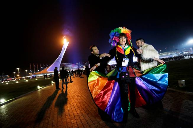 Vladimir Luxuria, center, a former Communist lawmaker in the Italian parliament and prominent crusader for transgender rights, is led away by friends to attend a women's ice hockey match after posing for photos on the Olympic Plaza at the 2014 Winter Olympics, Monday, Feb. 17, 2014, in Sochi, Russia. Luxuria was soon after detained by police upon entering the Shayba Arena.