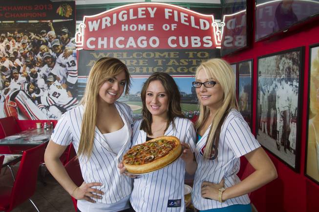 Servers, from left, Tiffany Shapouri, Susie Barajas, and Amanda Hewitt pose with a medium-size, three-topping, deep-dish pizza at Amore Taste of Chicago, 3945 S. Durango Dr., Wednesday, Feb. 19, 2014. This pizza ($20.50) has pepperoni, mushrooms and green peppers over fresh crushed tomatoes.