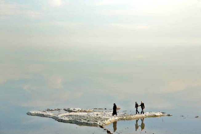 In this  Saturday, Feb. 15, 2014 photo, visitors walk on salt-covered rocks that were once deep underwater at Lake Oroumieh Lake, northwestern Iran.