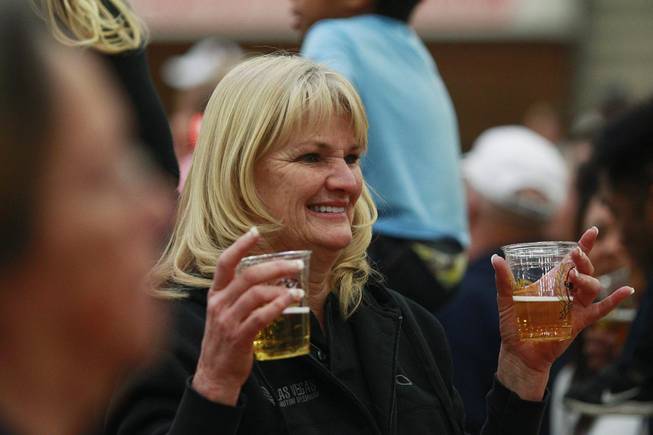 An attendee poses for a photo with her beer during an appearance of the Budweiser Clydesdales at the South Point Arena Thursday, Feb. 20, 2014.