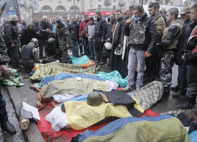 Activists pay respects to protesters who were killed in clashes with police in Kiev's Independence Square, the epicenter of the country's current unrest, Kiev, Ukraine, Thursday, Feb. 20, 2014. 
