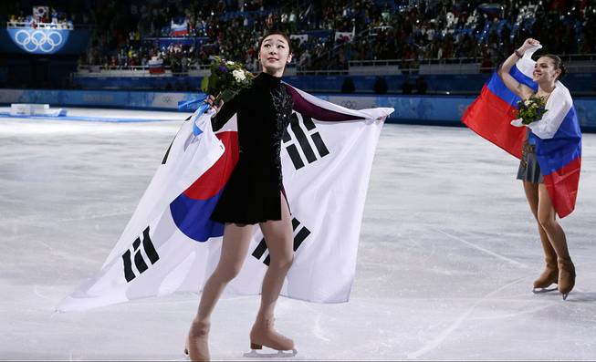 Yuna Kim of South Korea and Adelina Sotnikova of Russia skate on the ice after the flower ceremony for the women's free skate figure skating finals at Iceberg Skating Palace during the 2014 Winter Olympics, Thursday, Feb. 20, 2014, in Sochi, Russia. 