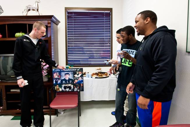 Kevin Brill talks about his younger brother, Aric, to their close friends, from right, Melvin Gibson, Jamal Martin and Moran during a ceremony celebrating the life of 16-year-old Aric Michael Brill, who donated six organs following his homicide five years ago, at the UMC Transplant Center Friday, February 21, 2014.