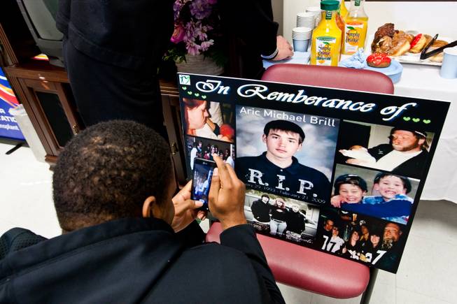 Melvin Gibson takes a photograph of memories of his close friend, Aric, during a ceremony celebrating the life of 16-year-old Aric Michael Brill, who donated six organs following his homicide five years ago, at the UMC Transplant Center Friday, February 21, 2014.