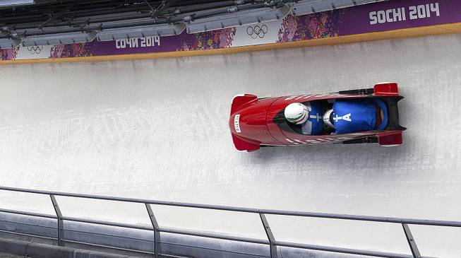 An Italian bobsled brakeman has his head down as he slides down the track at the Sanki Sliding Center during the 2014 Winter Olympics in Krasnaya Polyana, Russia, Feb. 13, 2014. 