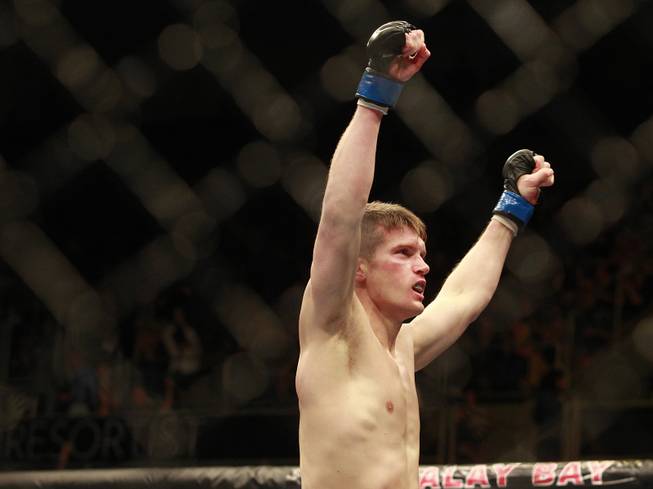 Stephen Thompson raises his arms after defeating Robert Whittaker during their fight at UFC 170 Saturday, Feb. 22, 2014 at the Mandalay Bay Events Center.