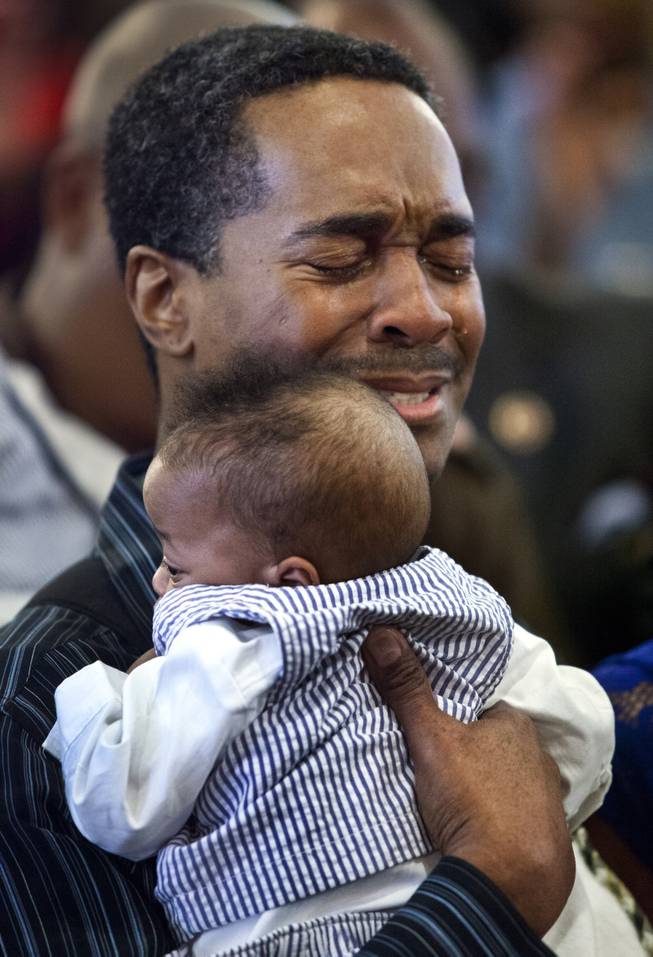 Deon Derrico cries near the alter at Victory Missionary Baptist Church as the quintuplets are welcomed to the church on Sunday, Feb. 23, 2014.