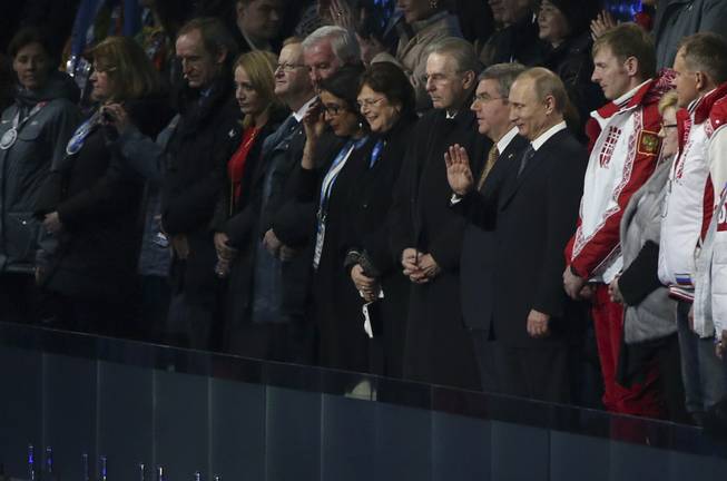 Vladimir Putin, president of Russia, waves as he is introduced during the closing ceremony for the 2014 Winter Olympics at Fisht Olympic Stadium in Sochi, Russia, Feb. 23, 2014. Left of Putin is Thomas Bach, president of the International Olympic Committee, and right of Putin is Russian bobsled gold medalist Alexander Zubkov. (Doug Mills/The New York Times)