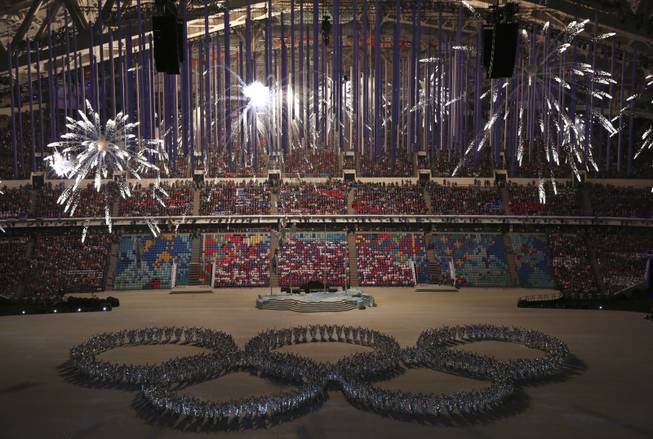 Fireworks erupt over a large group of perfomers forming a shape of the Olympic Rings during the closing ceremony for the 2014 Winter Olympics at Fisht Olympic Stadium in Sochi, Russia, Feb. 23, 2014. (Josh Haner/The New York Times).