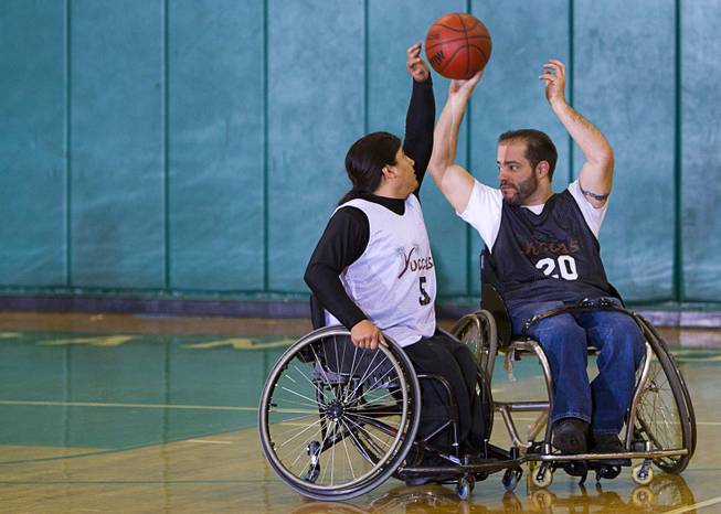 Steven Morales, left, defends against teammate Mike Humel during wheelchair basketball practice at Rancho High School Tuesday, Feb. 25, 2014. The team is practicing for a scrimmage against a Wounded Warriors team at Nellis Air Force Base on Thursday.