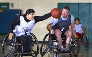 Steven Morales grabs a ball ahead of Marc Fenn during wheelchair basketball practice at Rancho High School Tuesday, Feb. 25, 2014. The team is practicing for a scrimmage against a Wounded Warriors team at Nellis Air Force Base on Thursday.