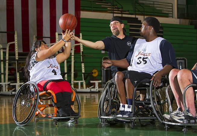 Cinthya Huendo, Jonathan Foster, center, and Timothy Oliver go after a rebound during wheelchair basketball practice at Rancho High School Tuesday, Feb. 25, 2014. Foster works for the City of Las Vegas and helps head the Las Vegas Paralympic Sport Club.