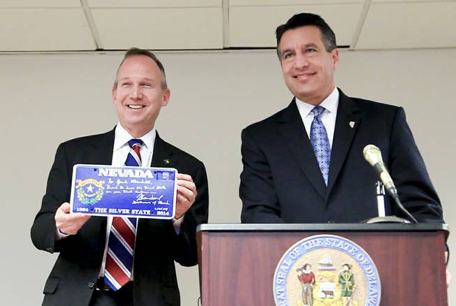 A screenshot of Nevada Gov. Brian Sandoval presenting Delaware Gov. Jack Markell with a Nevada sesquicentennial license plate as the two sign an agreement to pool their online poker venues in Wilmington, Del. Tuesday morning Feb. 25, 2014.